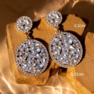 Detailed view of luxury gold-tone geometric drop earrings with sparkling rhinestones