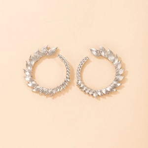Detail of silver leaf laurel hoop earrings with textured metal finish on a soft background