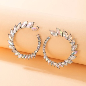 Detailed close-up of C-shaped silver earrings with iridescent marquise-cut crystals