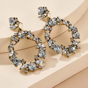 Macro shot of geometric hollow hoop earrings with crystals on a stone pedestal