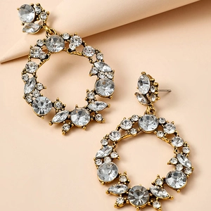 Macro detail of vintage gold hollow earrings with luxury crystal inlay and rhinestones