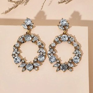 Detailed view of hollow geometric gold earrings with micro-pave crystals and rhinestones