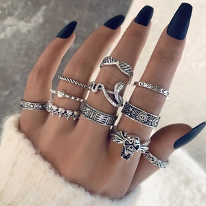 Detailed view of Gothic silver ring set featuring skull, moth and snake motifs on hand