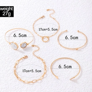 Detail view of five-piece gold bangle set with geometric charms and size measurements