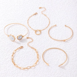 Close-up of 5-piece gold bracelet set with marble stones, hearts and geometric shapes