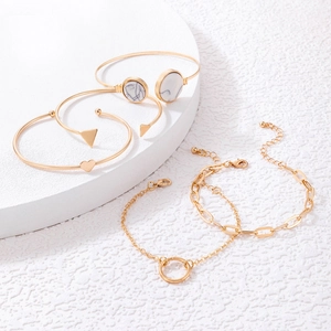 Detail of 5-piece gold bangle set with geometric heart, triangle, and marble motifs