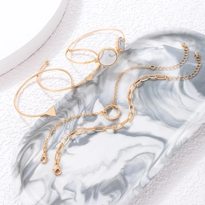Detail of 4-piece gold jewelry set with marble inlay on marble tray display
