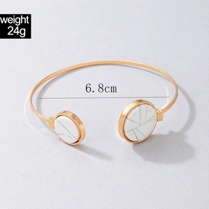 Detailed view of golden open cuff bracelet featuring grey marble stone ends with 6.8cm diameter