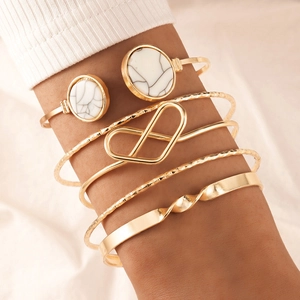 Detail of 6-piece gold geometric bracelet set with marble stone on model's wrist