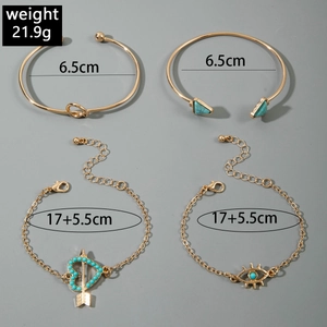 Detail of bohemian gold jewelry set with turquoise stone and evil eye charms