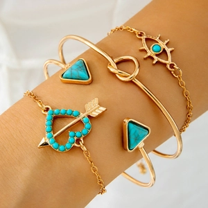 Detail of four-piece gold bohemian bracelet set with turquoise stones and evil eye charm