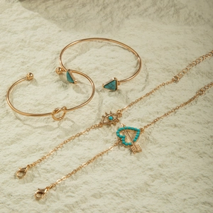 Detail of four-piece gold bohemian bracelet set with turquoise stones and charms