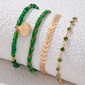 Detalle del set de cuatro tobilleras bohemias con cuentas verdes y concha dorada