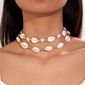 Detail of layered seashell choker with silver starfish charms worn on neck