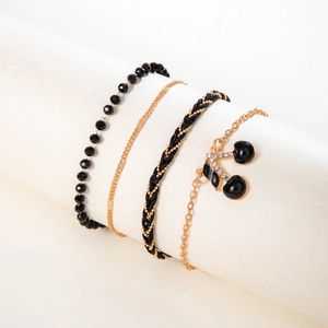 Close-up of beaded cherry anklet set with sparkling rhinestones and gold chains