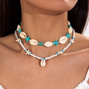 Close-up of double-layered beaded necklace with shells and turquoise stars