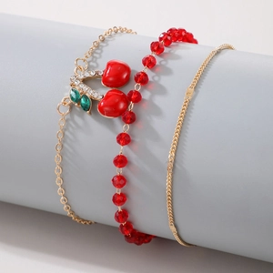 Detailed view of beaded cherry anklet set with red crystal beads and gold cherry charms