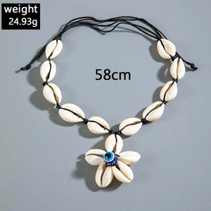 Detailed shell necklace with blue evil eye bead and 58cm length on grey background