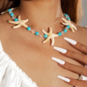 Detail of beach necklace featuring starfish pendant, blue turquoise beads and glass crystals