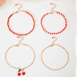 Close-up of red beaded multi-layer anklets set with rhinestone cherry pendants