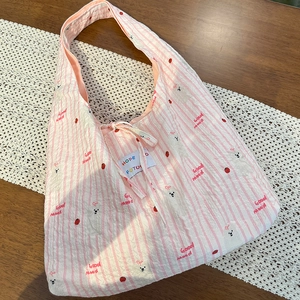 Detail of pink striped tote bag with cute bear patterns and tie closure design