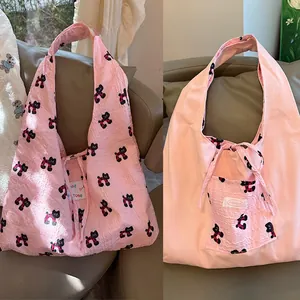 Detail view of pink dual-sided canvas bag with cat patterns and bow-knot closure