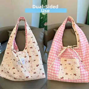 Detail of reversible tote bag showing dog embroidery and pink checkered pattern