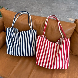 Large striped canvas tote bags in red and blue stripes for women on leather sofa