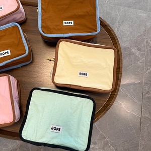 Detailed top view of stackable fabric cosmetic pouches with Hope labels and contrast piping