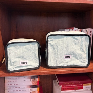 Detail of two-piece mint green nylon organizer bags with black trim and HOPE logo