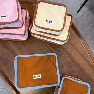 Close-up of fabric cosmetic bags with HOPE label and contrasting border details