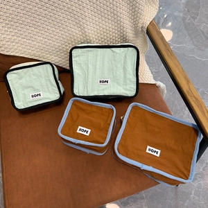 Macro shot of 4-piece nylon travel organizers with HOPE label on brown leather surface