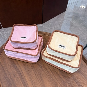 Pink and beige portable canvas storage bags with HOPE label for travel organization