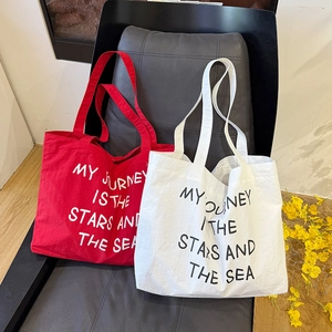 Detailed view of canvas tote bags with My Journey Is The Stars And The Sea text