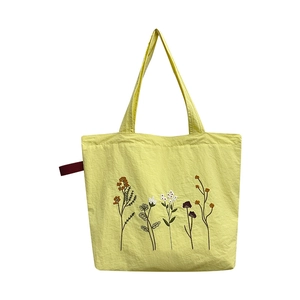 Yellow vintage nylon tote bag with floral embroidery and burgundy decorative ribbon