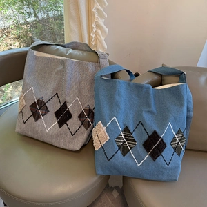 Close-up of denim and striped canvas tote bags with argyle embroidery on chairs