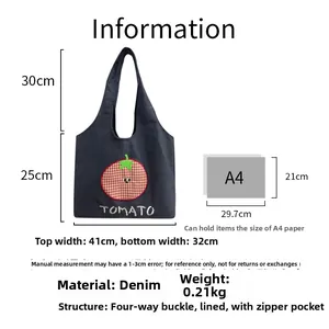 Detailed view of denim tote bag with tomato embroidery showing size comparison and interior