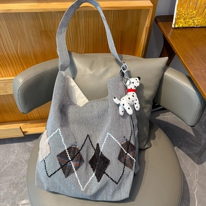 Detail view of canvas striped tote bag with diamond pattern and dalmatian plush charm