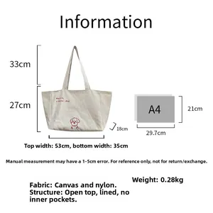 Detaillierter Größenvergleich der Canvas-Tasche mit Hundestickerei und A4-Papierformat