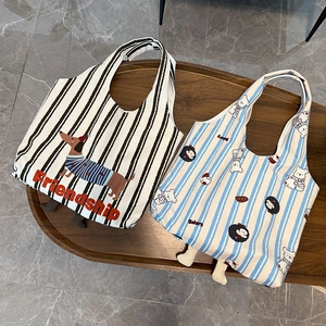 Detail of canvas tote bags with horizontal stripes and cute 3D leg decorations