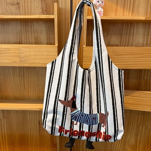 Detail of white canvas tote with striped dachshund print and Friendship text