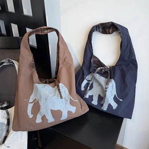 Detail of large tote bag showing elephant print, plaid lining and drawstring detail