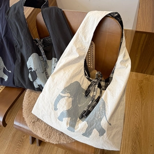 Detail of canvas tote bag with elephant print and black and white checkered bow tie