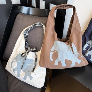 Close-up of elephant print tote bags with plaid drawstring ribbons and inner lining