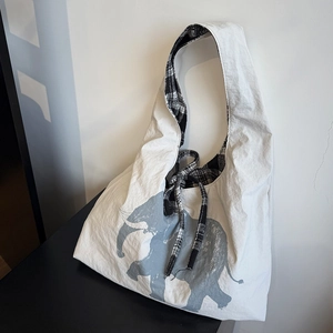 Detail of white tote bag featuring elephant print and black and white plaid drawstring