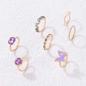 Detailed view of a 6-piece purple gemstone and butterfly gold-plated ring set
