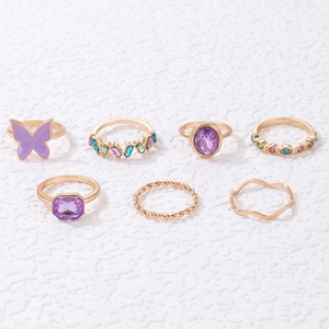Detailed set of 7 gold rings featuring purple butterfly enamel and gemstone accents