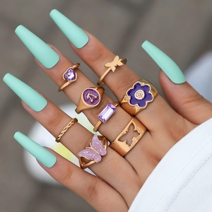 Detailed close-up of 8-piece gold butterfly ring set with purple stones and enamel