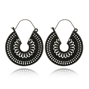 Macro shot of matte black bohemian hollow round earrings with intricate geometric patterns