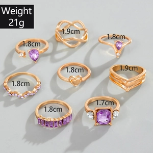 Detail of 8-piece gold-tone ring set featuring purple gemstones and weight 21g specs